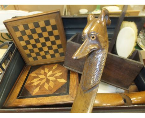 A tin trunk and crate of various treen ware, games pieces, chequered games board, candlebox, mirror, shoe trees, treen ware p