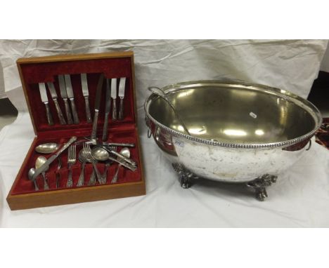 A plated punch bowl with cast lion head handles and raised on paw feet (formerly a food dome), together with a plated ladle a