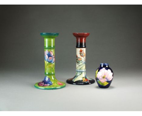A Moorcroft Anemones pattern candlestick decorated with dark pink flowers and green foliage on a green ground, 20.5cm high, a