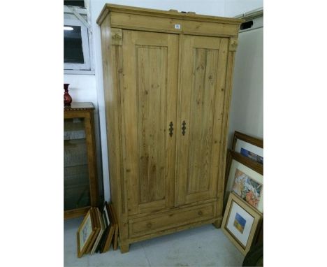 An antique pine two door wardrobe