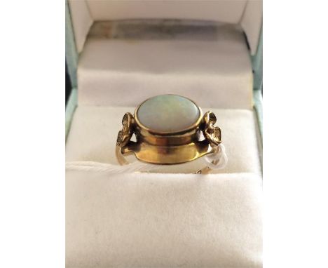 A 9 ct gold opal ring decorated with flowers on the shoulders