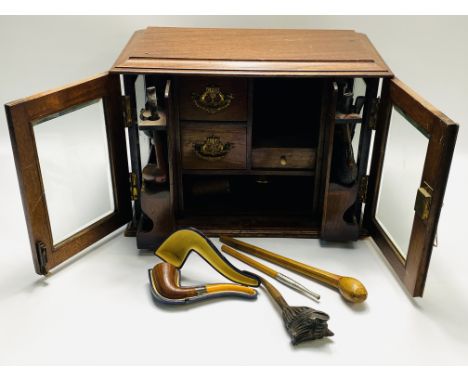 An Edwardian mahogany and bevelled glass cased smokers cabinet, to include a cased amber and silver mounted pipe,and various 