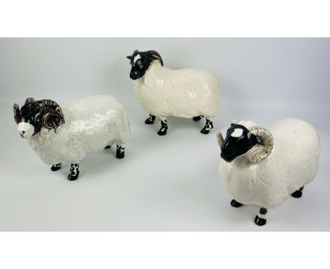 Three large David Sharp ceramic sheep, one fashioned as a money box, all with backstamps to the undersides, largest 23cms wid