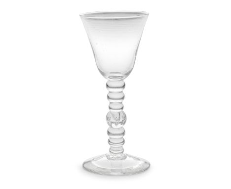 A rare bobbin-knopped baluster goblet, circa 1735-45The slightly flared round funnel bowl set on a tall multi-knopped stem co