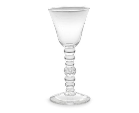 A rare bobbin-knopped baluster goblet, circa 1735-45The slightly flared round funnel bowl set on a tall multi-knopped stem co