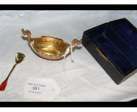 A cased Norwegian silver gilt and red enamel "Viking ship" salt cellar with glass liner and matching spoon 