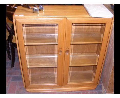 An Ercol 'Golden Dawn' side cabinet, enclosed by a pair of glazed doors - width 90cm 