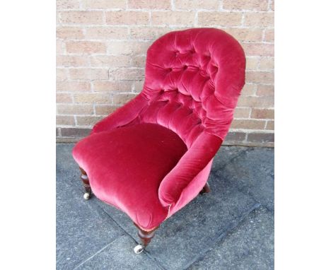 A VICTORIAN BUTTON BACK NURSING CHAIR on turned frontal supports and castors 