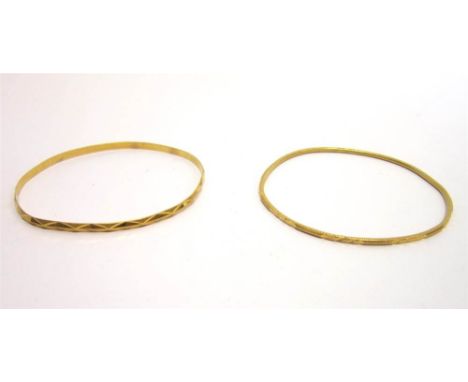 A CONTINENTAL BANGLE with diamond cut decoration; with another similar bangle; 18g gross