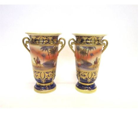 A PAIR OF NORITAKE PORCELAIN TWIN HANDLED VASES  hand-painted Bedouin Arabian scenes, with gilt overlay detail to the border,