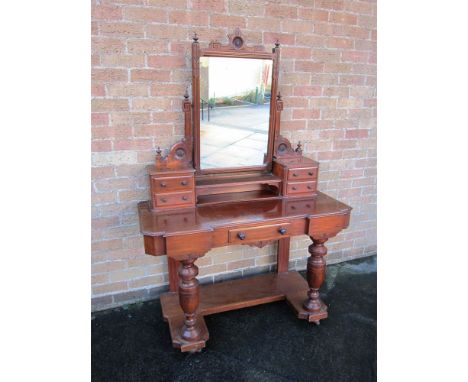 A MAHOGANY DRESSING TABLE the rectangular swing mirror flanked by four trinket drawers and with central drawer under, the twi