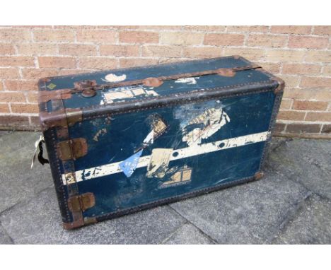 A LARGE METAL BOUND TRAVELLING TRUNK With 'Selfridges London' retailers label, the interior fitted with hangers and hinged co