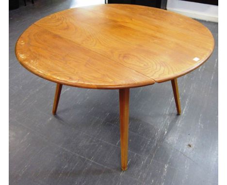 AN ERCOL LIGHT ELM OVAL TWO-LAP DINING TABLE with a set of four stick back Dining Chairs