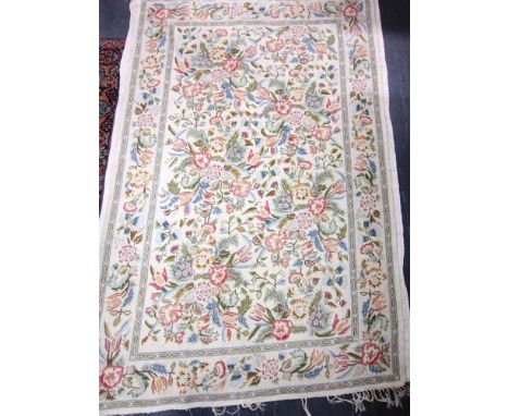 A HANDWOVEN TAPESTRY RUG of floral design on a cream ground, 177 x 120cm