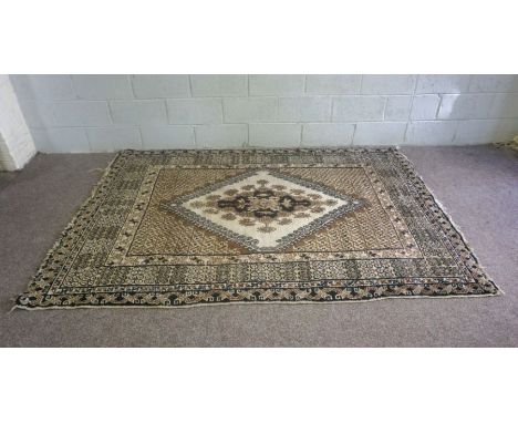 A large modern wool rug, with central lozenge on light cream and brown ground, 250cm x 175cm; together with a smaller similar