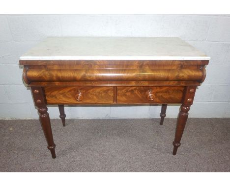 A Victorian mahogany console table, circa 1860, with a rectangular white marble top over an unusual cushion front concealed d