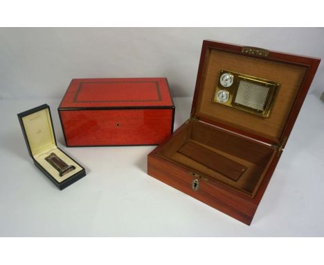 A vintage Dunhill burr maple and ruby laquered humidor box, 15cm high, 36cm wide; together with a cased Dunhill table lighter
