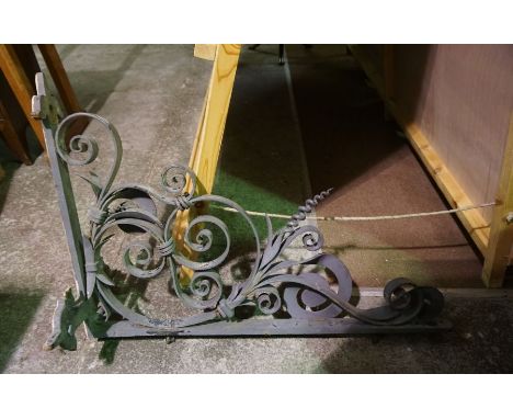 A large wrought iron coaching inn or shop swing sign bracket, early 20th century, with scrolled supports and stiff leaf decor