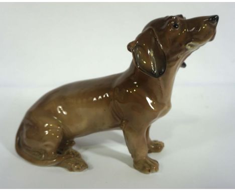 A vintage German Volkstedt figure of a Dachshund (Sitzender Dackel), 22cm high, 26cm long