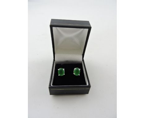 A pair of jade ear studs, claw set in white metal, stamped 925, 2.1g.