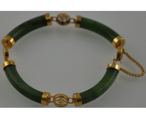 A jade bracelet, the curved batons with gilt metal mounts, 18.3g. 
