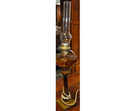 An early 20th Century gilt metal and marble oil lamp with amber glass reservoir converted to electricity