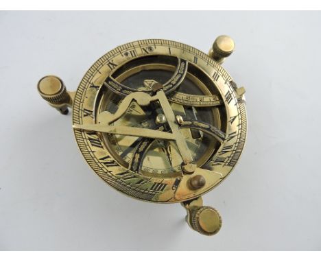 A brass table sundial, with three adjustable feet, D. 11cm.