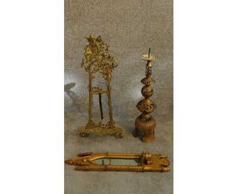 A collection of brass items and a giltwood gothic style mirror. A pierced brass floor candlestick with scrolling foliate moti