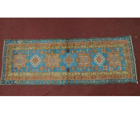 A Persian Heriz style runner, repeating stylised medallion throughout the field guarded by multi stylised geometric border246