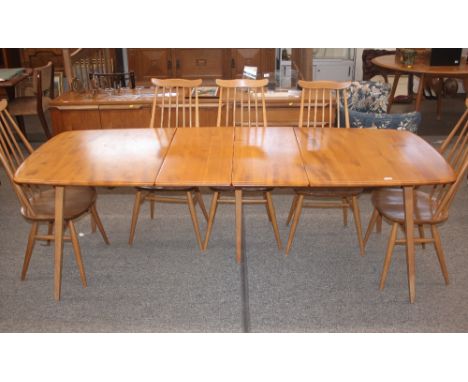 A light Ercol extending dining table, fitted two extra leaves raised on tapering square section supports 