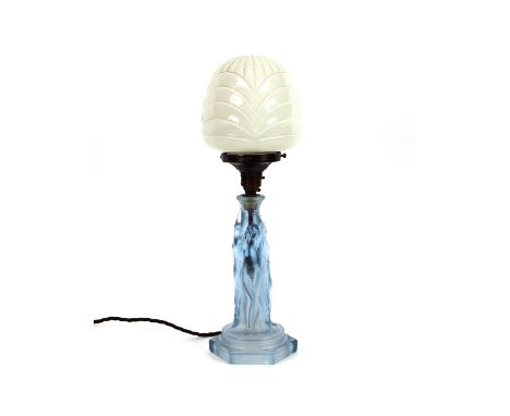 An Art Deco blue glass table lamp, the column decorated naked female figures beneath an opaque globe shade, 47cm high 