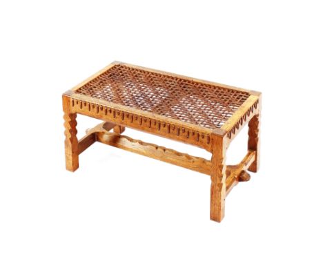 A good quality oak Arts &amp; Crafts style stool, with leather strap work upholstery raised on square section supports united