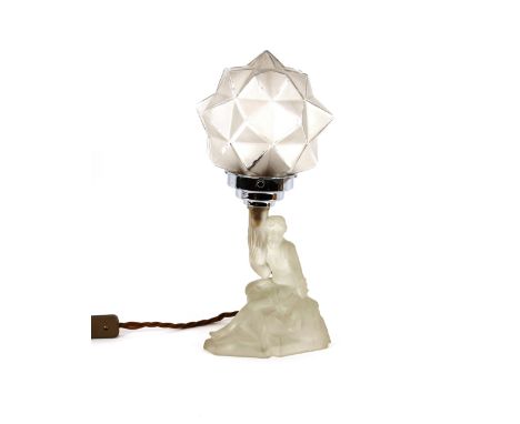 An Art Deco frosted glass table lamp, in the form of a lady seated on a rock holding lamp aloft with angular glass globe shad