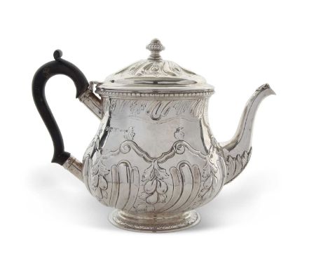 Edwardian silver teapot of slight baluster form, the hinged lid and body decorated with a fluted and leaf design, having a ur