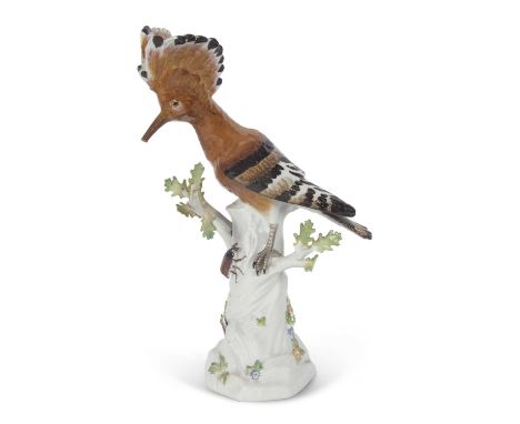 A Meissen model of a Hoopoe bird on a tree trunk, the trunk decorated with insects and flowers, blue cross swords mark to bas