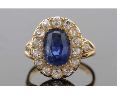 A sapphire and diamond ring, the oval mixed cut sapphire, surrounded by old mine cut diamonds, all claw mounted with old mine