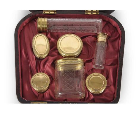 An Asprey &amp; Co cased set of silver-gilt topped and engraved glass bottles and jars, hallmarked for London 1911, Asprey &a