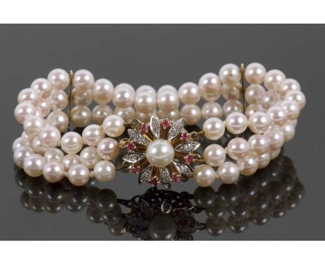 An 18ct cultured pearl, ruby and diamond bracelet, the three rows of round cultured pearls, each approx. 6.1mm diameter, with