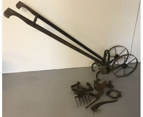 A vintage wooden handled Planet Junior push cultivator complete with a selection of attachments. Wooden handles have original