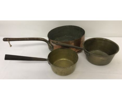 Three vintage handled saucepans. A large copper pan with 2 smaller brass pans.
