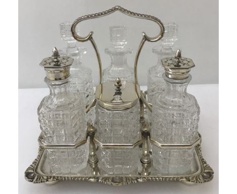 A vintage cut glass and silver plated Atkins Brothers 6 bottle cruet set and frame. Frame is raised on 4 bun feet, cut glass 