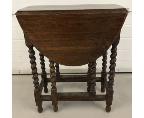 A small oak drop leaf, gate leg table with barley twist legs.