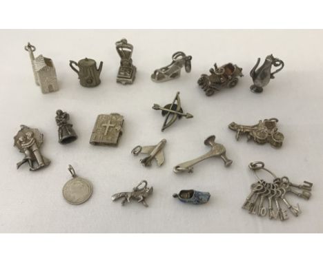 A collection of silver and white metal vintage charms. Comprising : croft, butchers scales, urn, vintage car, Elizabethan lad