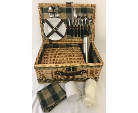 A modern wicker picnic set for 2 to include crockery, cutlery, glasses and a thermos flask.