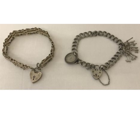 Two vintage silver charm bracelets. One gate style with padlock clasp, safety chain missing, and the other a double curb link