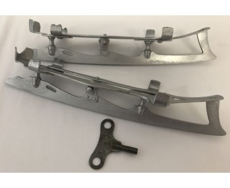 A pair of vintage metal ice skates attachments with adjusting key.