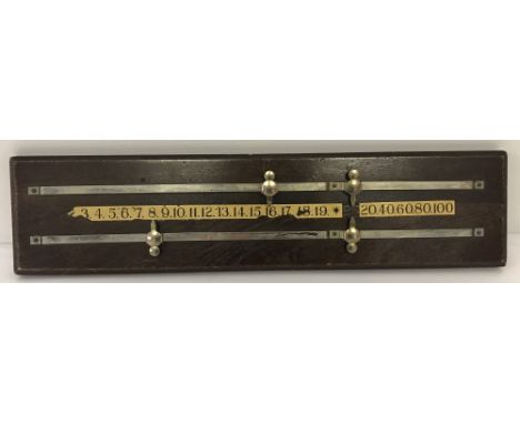 A vintage dark wood snooker score board with four metal sliding score pegs.