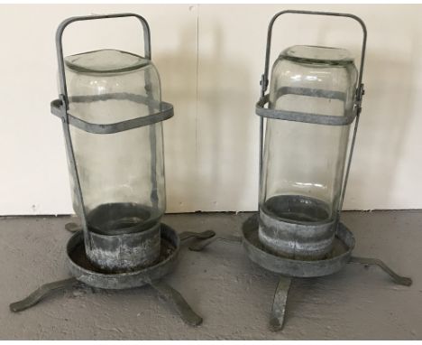 A pair of vintage galvanized metal and glass bird drinkers.