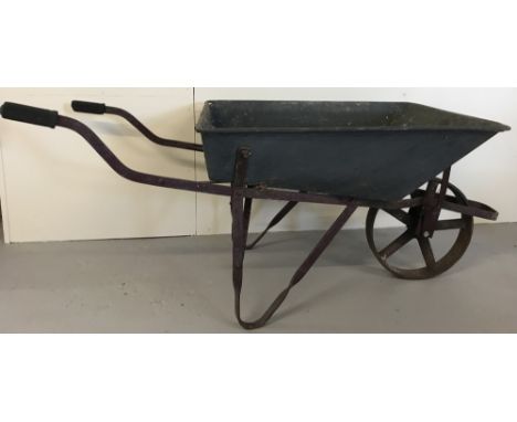 A vintage wheelbarrow. Galvanized metal body with cast iron frame, handles and wheel.