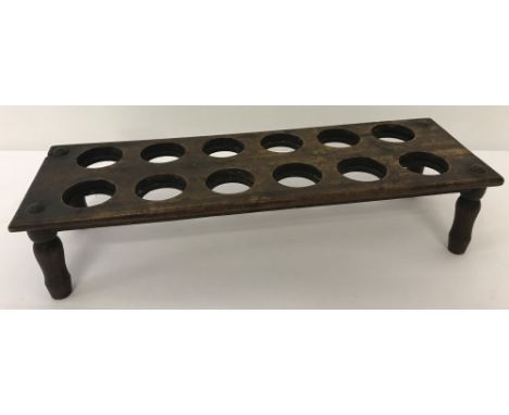 A vintage wooden egg rack on four small turned legs. Holds ten eggs.